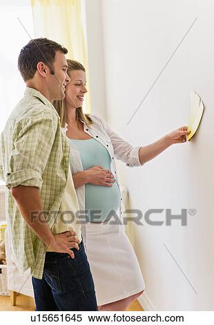 Young couple choosing wall color for nursery View Large Photo Image Stock Photography - Young couple choosing wall color for nursery. Fotosearch