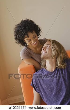 Picture - Young couple in living room. Fotosearch