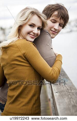 Young couple on pier, woman looking at camera View Large Photo Image Stock Image - Young couple on pier, woman looking at camera. Fotosearch