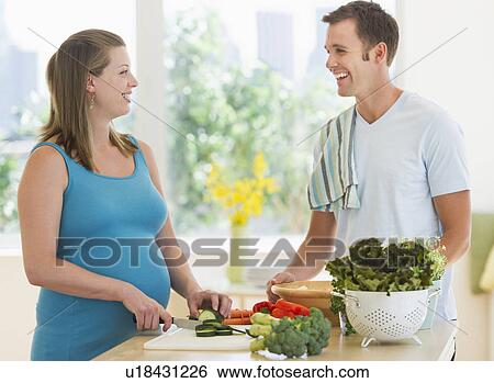 Stock Photograph - Young couple preparing food. Fotosearch