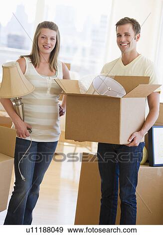 Stock Photo - Young couple unpacking. Fotosearch