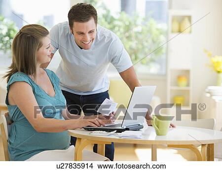 Young couple using laptop View Large Photo Image Picture - Young couple using laptop. Fotosearch