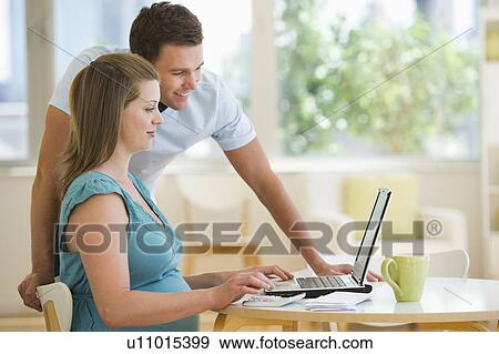 Young couple using laptop View Large Photo Image Stock Photo - Young couple using laptop. Fotosearch