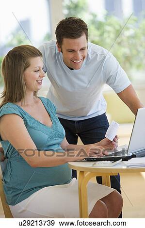 Stock Photo - Young couple using laptop. Fotosearch