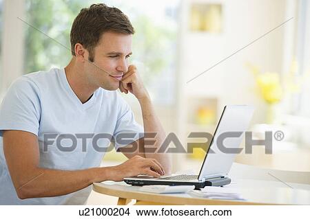 Picture - Young man using laptop. Fotosearch