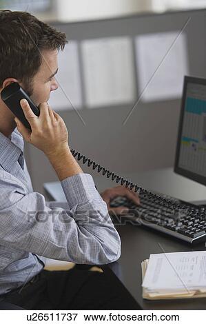 Stock Photo - Young man working in office. Fotosearch