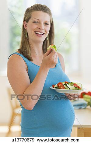 Young pregnant woman having salad View Large Photo Image Stock Photo - Young pregnant woman having salad. Fotosearch