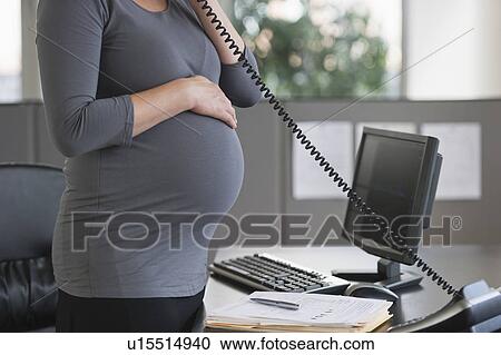 Young pregnant woman working in office View Large Photo Image Stock Image - Young pregnant woman working in office. Fotosearch