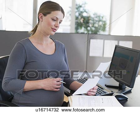 Young pregnant woman working in office View Large Photo Image Stock Image - Young pregnant woman working in office. Fotosearch