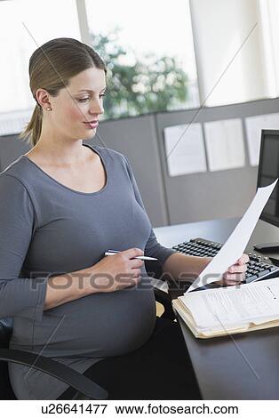 Young pregnant woman working in office View Large Photo Image Stock Photo - Young pregnant woman working in office. Fotosearch