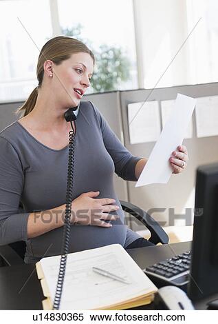 Young pregnant woman working in office View Large Photo Image Stock Photography - Young pregnant woman working in office. Fotosearch