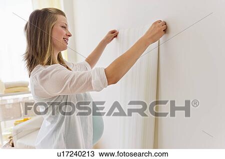 Young woman choosing wallpaper for nursery View Large Photo Image Stock Image - Young woman choosing wallpaper for nursery. Fotosearch