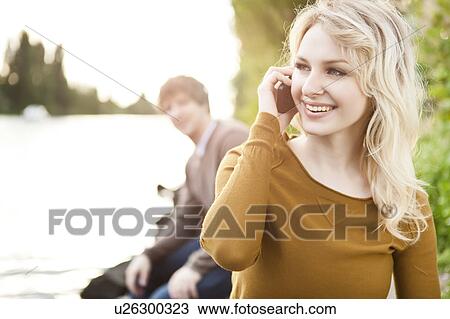 Stock Image - Young woman talking on phone. Fotosearch