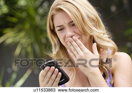 Young woman text-messaging, with facial expression View Large Photo Image Stock Image - Young woman text-messaging, with facial expression. Fotosearch