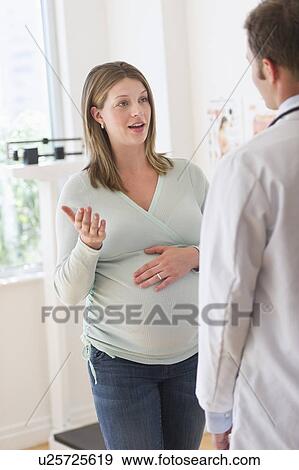 Young woman with doctor in doctor's office View Large Photo Image Stock Photo - Young woman with doctor in doctor's office. Fotosearch