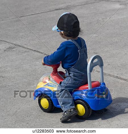 Stock Image - Boy riding a tricycle, Puerto Baquerizo Moreno, San Cristobal Island, Galapagos Islands, Ecuador. Fotosearch