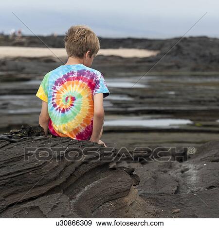 Boy sitting on the coast, Puerto Egas, Santiago Island, Galapagos Islands, Ecuador View Large Photo Image Stock Photo - Boy sitting on the coast, Puerto Egas, Santiago Island, Galapagos Islands, Ecuador. Fotosearch