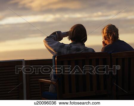 Couple sitting on chairs looking at a view, Galapagos Islands, Ecuador View Large Photo Image Stock Photograph - Couple sitting on chairs looking at a view, Galapagos Islands, Ecuador. Fotosearch