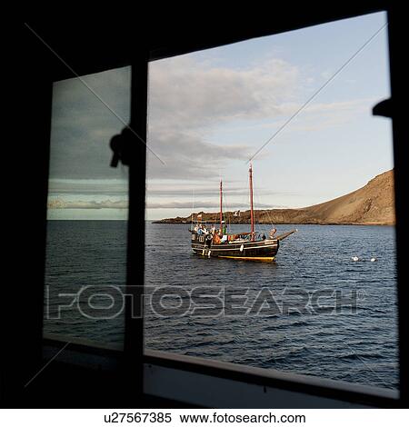 Stock Photography - Fishing boat viewed from the window of another boat, Bartolome island, Galapagos Islands, Ecuador. Fotosearch