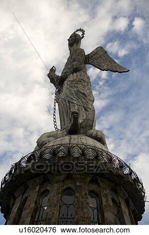 Stock Photograph - Low angle view of the statue of winged Virgin Mary of Quito, El Panecillo Hill, Quito, Ecuador. Fotosearch