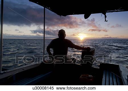 Man sitting on a boat, Puerto Baquerizo Moreno, San Cristobal Island, Galapagos Islands, Ecuador View Large Photo Image Stock Photography - Man sitting on a boat, Puerto Baquerizo Moreno, San Cristobal Island, Galapagos Islands, Ecuador. Fotosearch
