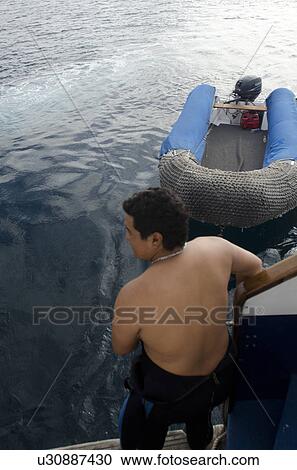 Man standing on the boat, Bartolome Island, Galapagos Islands, Ecuador View Large Photo Image Stock Image - Man standing on the boat, Bartolome Island, Galapagos Islands, Ecuador. Fotosearch