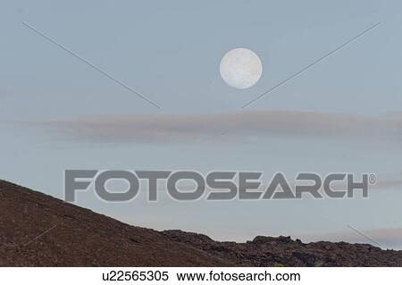 Stock Photography - Moon in the sky, Bartolome island, Galapagos Islands, Ecuador. Fotosearch