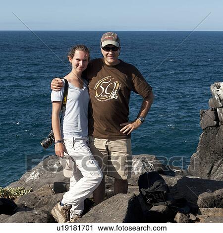 Stock Image - Portrait of a couple smiling on the coast, Punta Suarez, Espanola Island, Hood Island, Galapagos Islands, Ecuador. Fotosearch