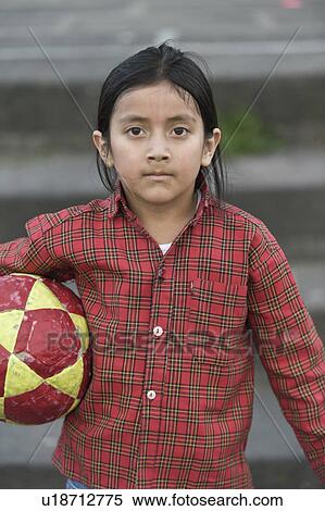 Stock Photography - Portrait of a girl holding a football under the arm, Quito, Ecuador. Fotosearch