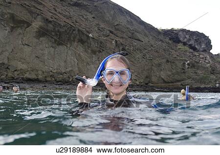 Picture - Scuba diver holding scuba gear, Bartolome Island, Galapagos Islands, Ecuador. Fotosearch
