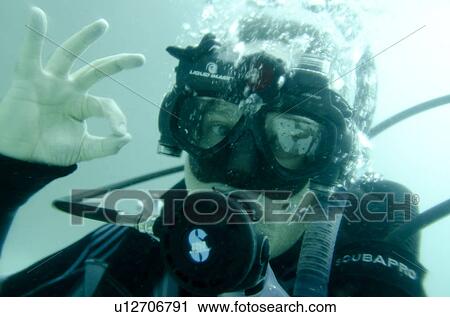 Stock Image - Scuba diver making an ok sign underwater, San Cristobal Island, Galapagos Islands, Ecuador. Fotosearch