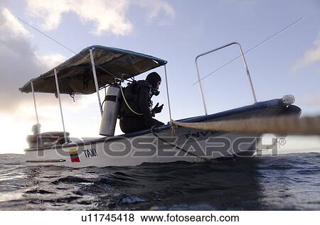 Scuba diver sitting on the ledge of a boat, San Cristobal Island, Galapagos Islands, Ecuador View Large Photo Image Stock Photo - Scuba diver sitting on the ledge of a boat, San Cristobal Island, Galapagos Islands, Ecuador. Fotosearch