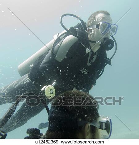 Stock Photo - Scuba divers swimming underwater, Santa Cruz Island, Galapagos Islands, Ecuador. Fotosearch
