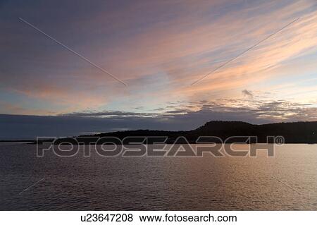Stock Photo - Silhouette of an island at dusk, Puerto Baquerizo Moreno, San Cristobal Island, Galapagos Islands, Ecuador. Fotosearch