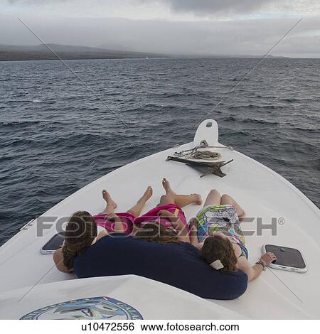 Stock Photograph - Three women resting on a boat, Ecuador. Fotosearch