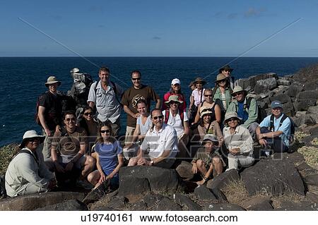 Stock Image - Tourists on volcanic rocks on the beach, Punta Suarez, Espanola Island, Galapagos Islands, Ecuador. Fotosearch