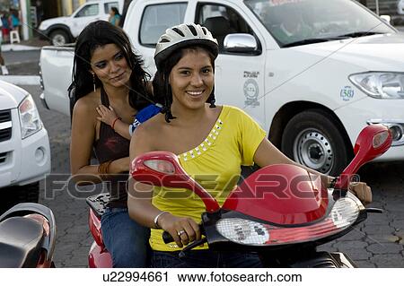 Woman riding a moped and smiling, Puerto Ayora, Santa Cruz Island, Galapagos Islands, Ecuador View Large Photo Image Stock Image - Woman riding a moped and smiling, Puerto Ayora, Santa Cruz Island, Galapagos Islands, Ecuador. Fotosearch