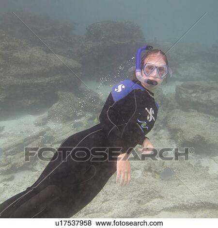 Stock Photo - Woman scuba diving underwater, Puerto Egas, Santiago Island, Galapagos Islands, Ecuador. Fotosearch