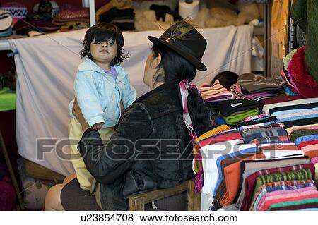 Woman with her daughter sitting in a clothing store, Quito, Ecuador View Large Photo Image Stock Photo - Woman with her daughter sitting in a clothing store, Quito, Ecuador. Fotosearch