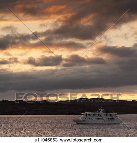 Stock Image - Yacht in the ocean at sunset, Santiago Island, Galapagos Islands, Ecuador. Fotosearch
