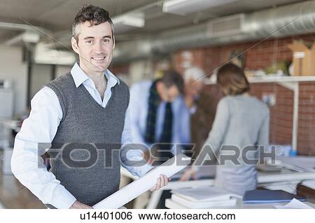 Stock Photograph - Architect carrying blueprint in office. Fotosearch