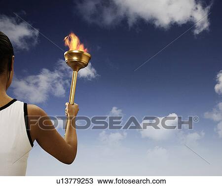 Athlete holding flaming baton View Large Photo Image Stock Image - Athlete holding flaming baton. Fotosearch