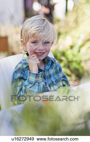 Boy eating at table outdoors View Large Photo Image Stock Photo - Boy eating at table outdoors. Fotosearch