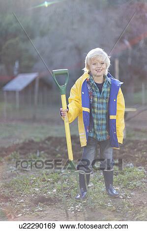 Boy holding pitchfork in garden View Large Photo Image Stock Photo - Boy holding pitchfork in garden. Fotosearch