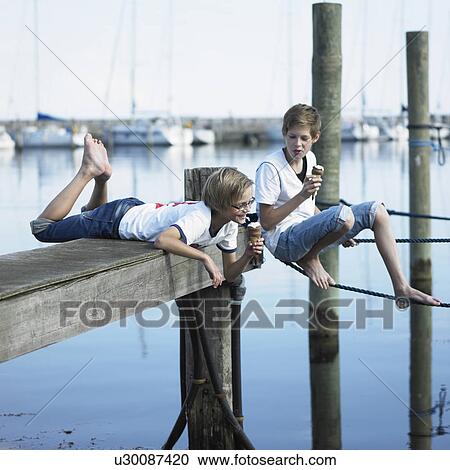 Boys eating ice cream on pier View Large Photo Image Stock Image - Boys eating ice cream on pier. Fotosearch