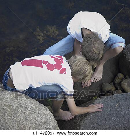 Stock Photo - Boys playing in river. Fotosearch