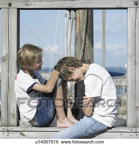 Stock Photography - Boys sitting on pier. Fotosearch
