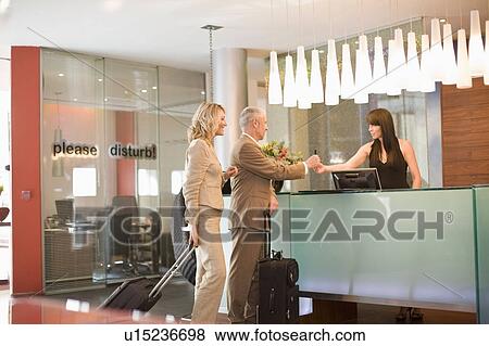 Business people checking into hotel View Large Photo Image Stock Photo - Business people checking into hotel. Fotosearch
