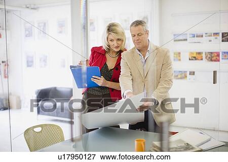 Stock Photo - Business people examining blueprints. Fotosearch