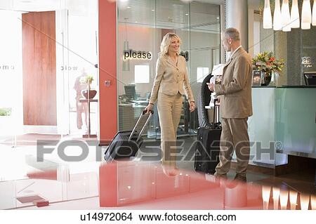 Business people rolling luggage in hotel View Large Photo Image Picture - Business people rolling luggage in hotel. Fotosearch